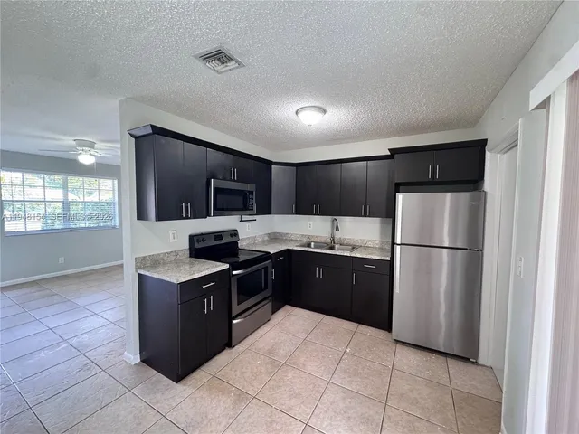 a kitchen with a refrigerator and a sink
