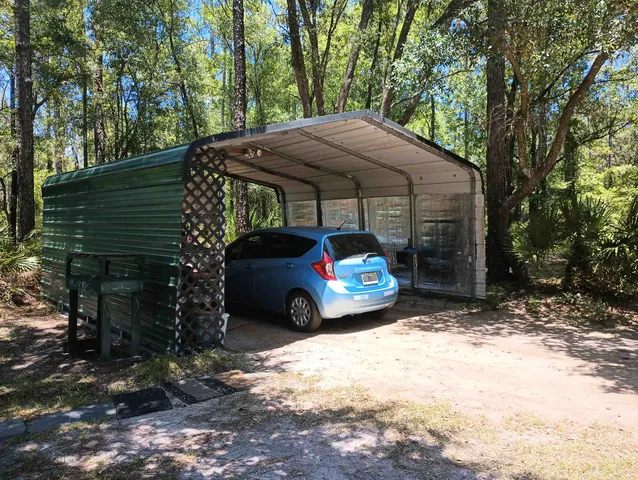 a backyard of a house with table and chairs under an umbrella