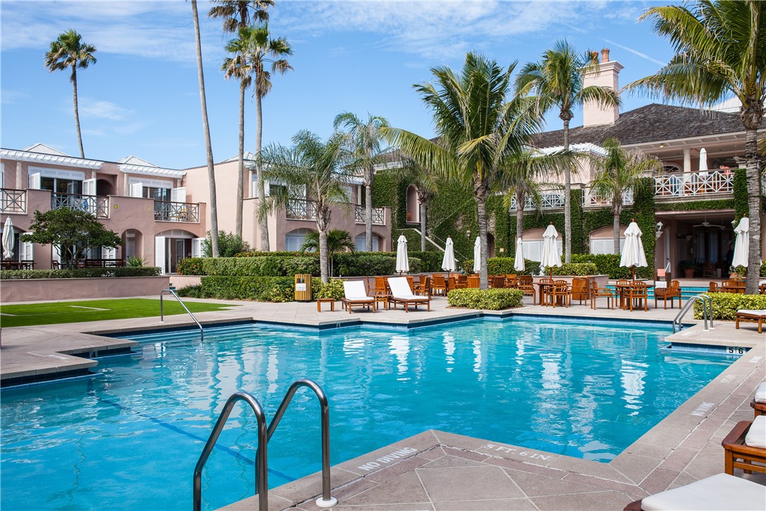 11 Caribe Way Vero Beach, FL 32963 - Photo 33 of 34 a view of a swimming pool with a lawn chairs under palm trees