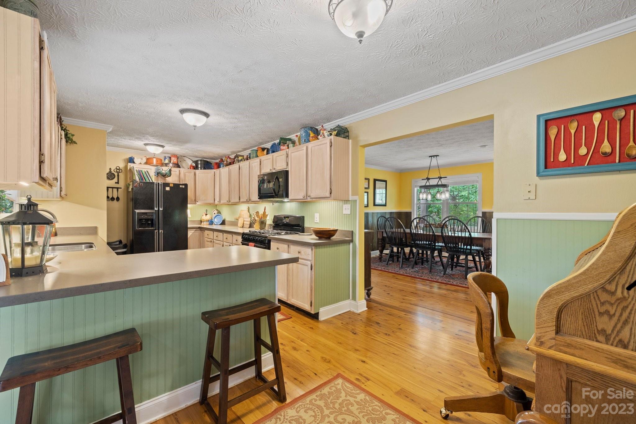 7 Quail Pointe Fletcher, NC 28732 - Photo 13 of 36 a kitchen with a table chairs refrigerator and cabinets