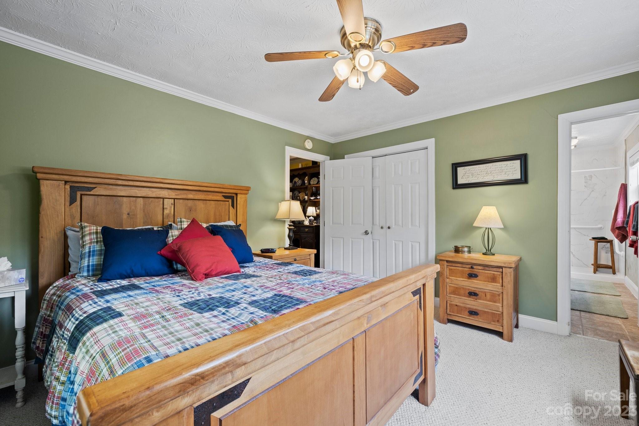 7 Quail Pointe Fletcher, NC 28732 - Photo 15 of 36 a bedroom with a large bed and a chandelier