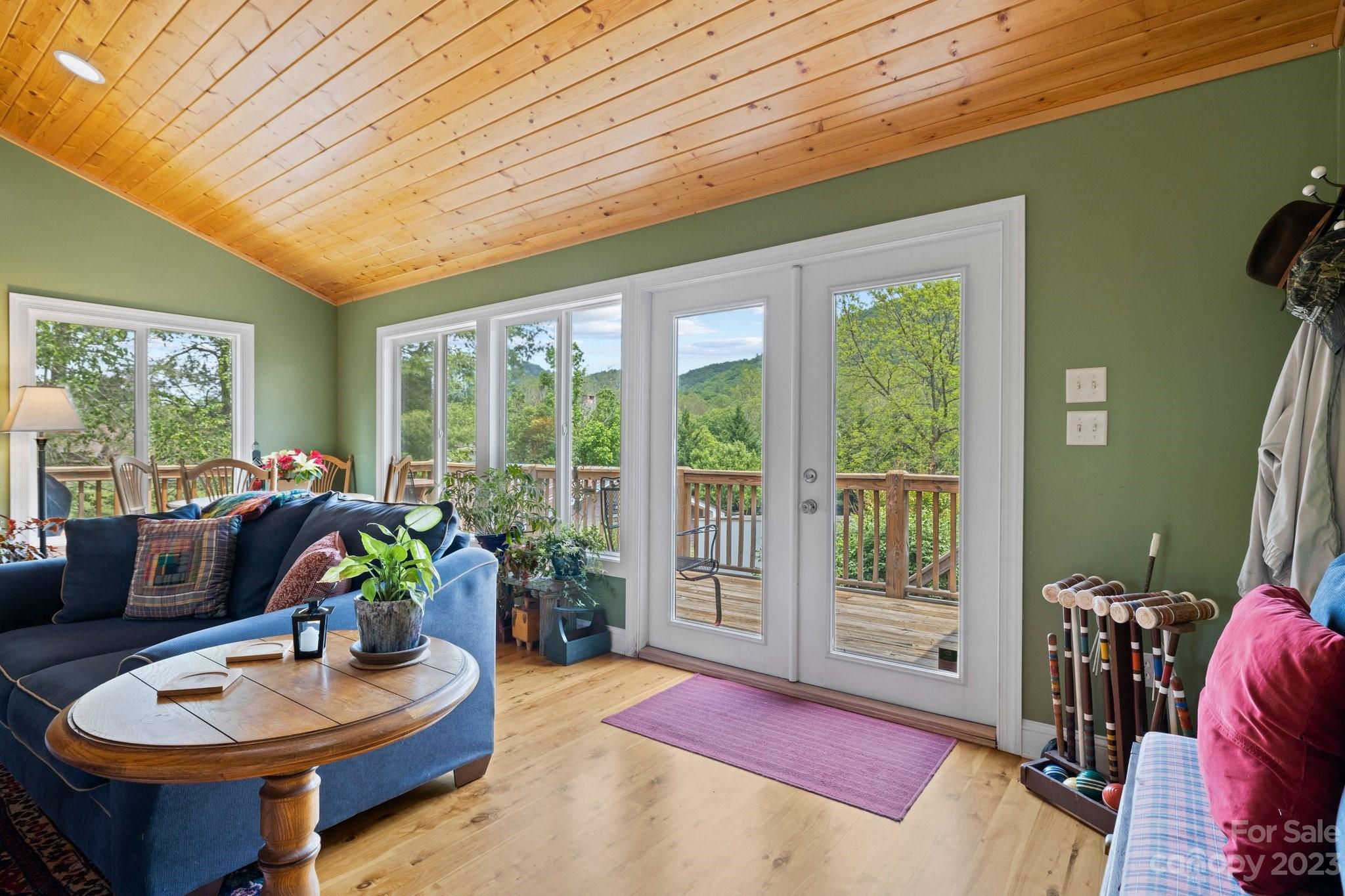 7 Quail Pointe Fletcher, NC 28732 - Photo 4 of 36 a living room with furniture a flat screen tv and a floor to ceiling window