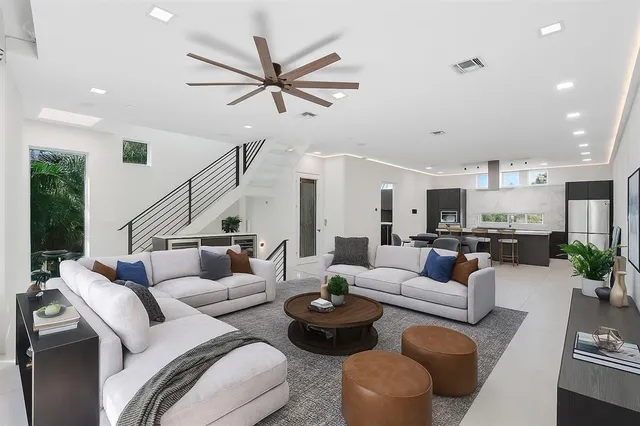 a living room with furniture and a view of kitchen