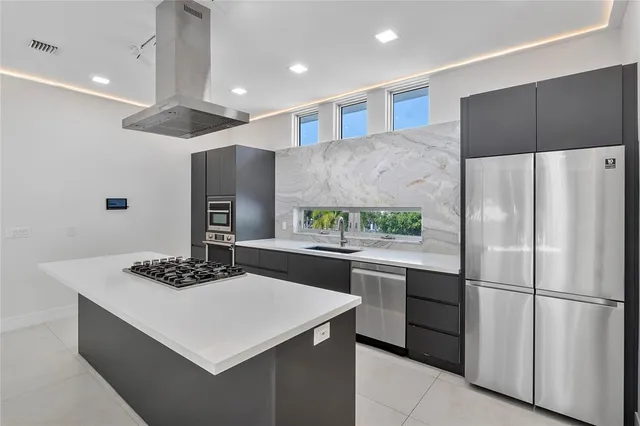 a kitchen with stainless steel appliances a refrigerator a sink and a stove