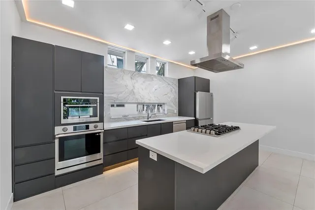 a view of kitchen with kitchen island stainless steel appliances sink refrigerator and microwave