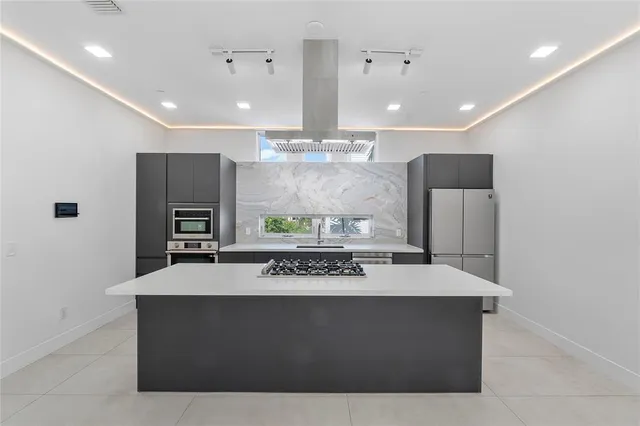 a kitchen with stainless steel appliances granite countertop a sink a stove and a refrigerator