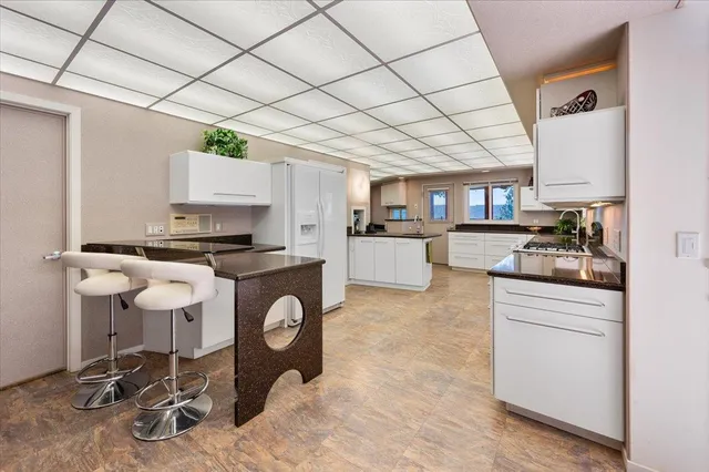 a kitchen with stainless steel appliances granite countertop a sink and a large window