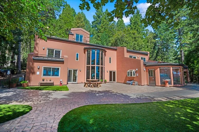 a view of a house with backyard and trees