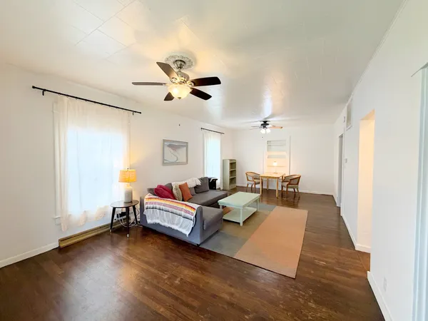 a living room with furniture and wooden floor