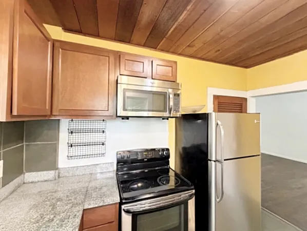 a kitchen with a refrigerator and a stove top oven