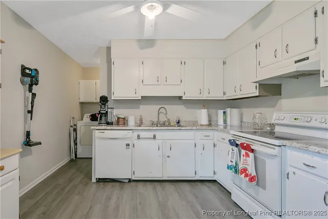 a kitchen with cabinets appliances and a wooden floor