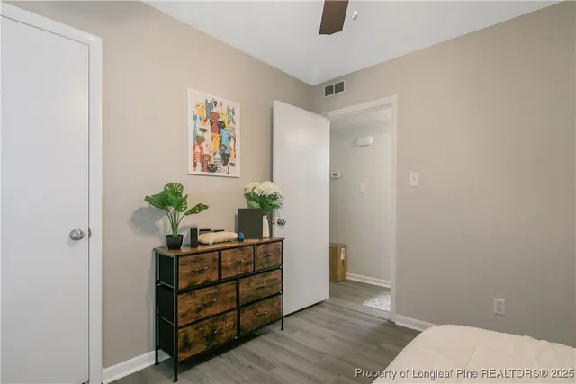 a view of a hallway with wooden floor and a potted plant