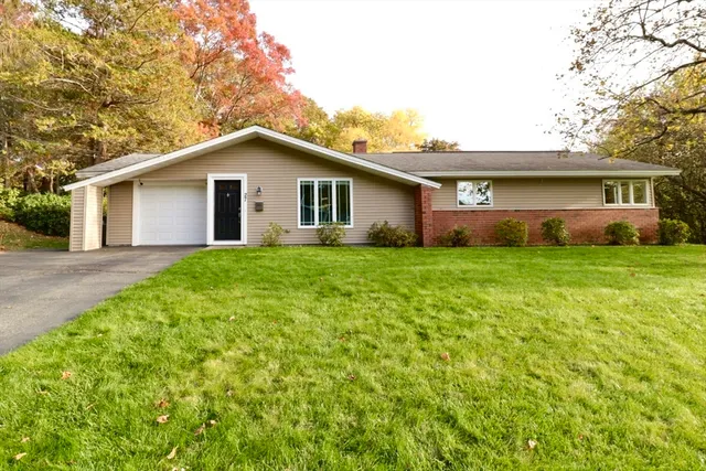 a house that is sitting in the grass with large trees