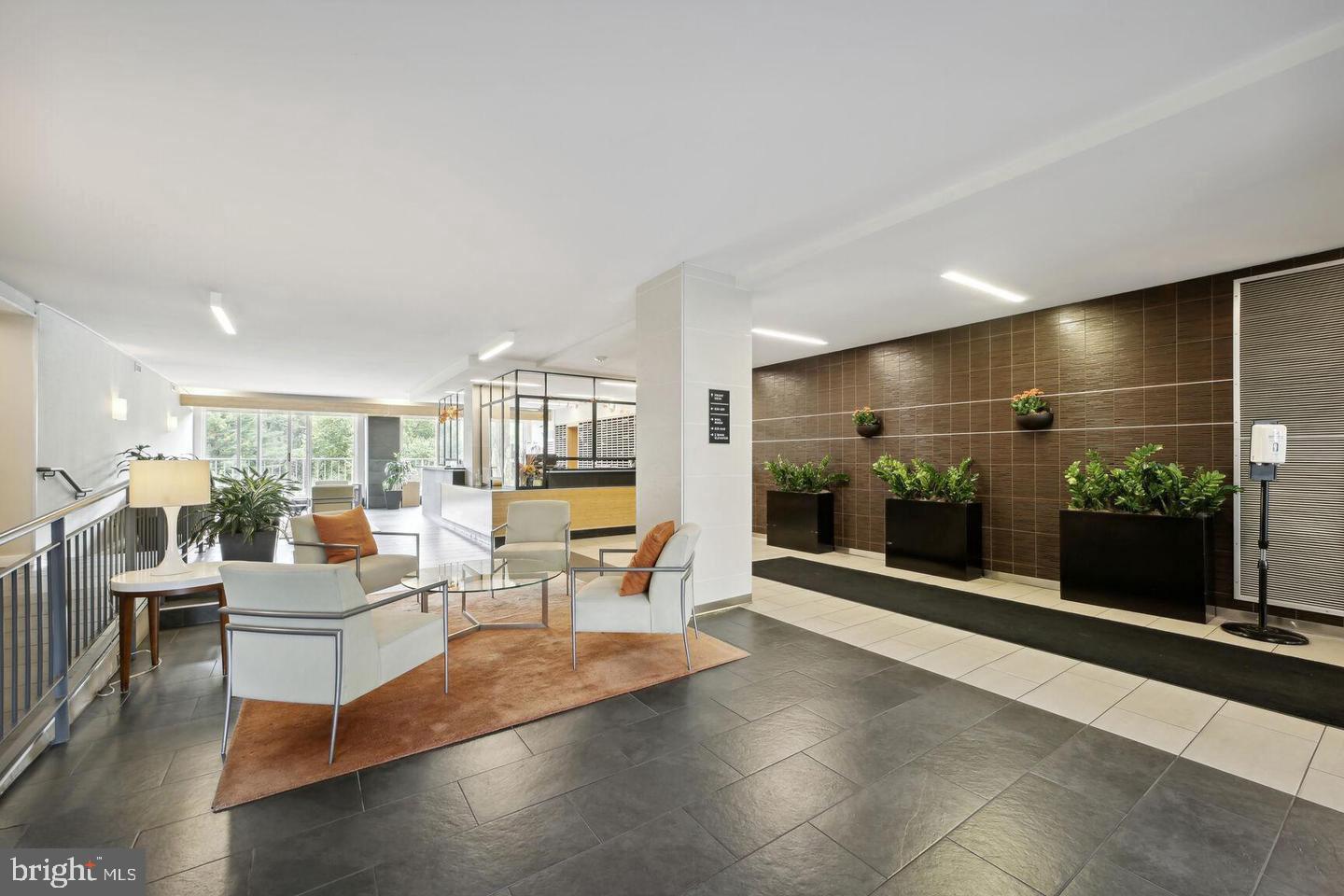 2939 Van Ness Street Northwest, Unit 845 Washington, DC 20008 - Photo 20 of 22 a living room with furniture a flat screen tv and a floor to ceiling window