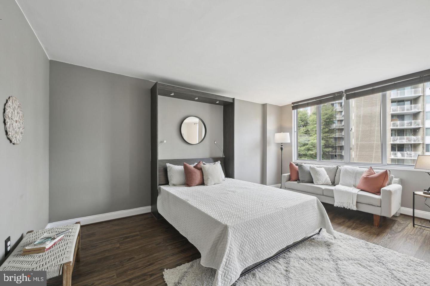 2939 Van Ness Street Northwest, Unit 845 Washington, DC 20008 - Photo 4 of 22 a bedroom with a bed couch and window