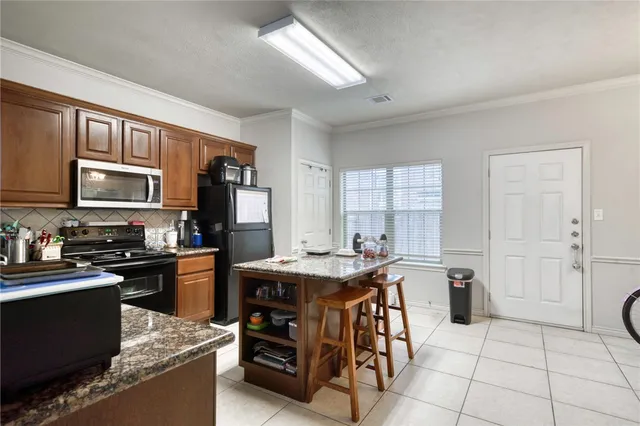 a kitchen with stainless steel appliances granite countertop a stove top oven a sink dishwasher and a refrigerator