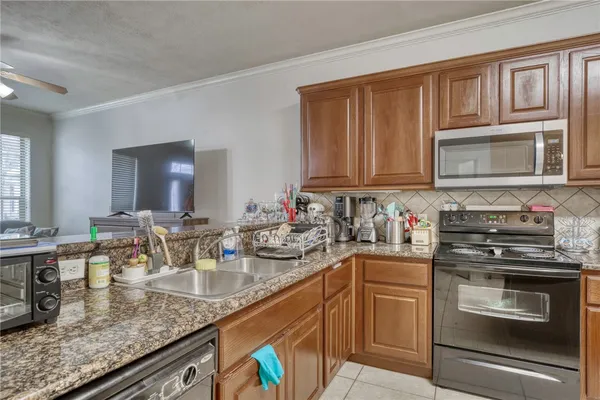 a kitchen with stainless steel appliances granite countertop a sink stove and microwave