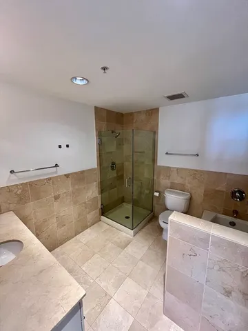 a bathroom with a tub shower and sink