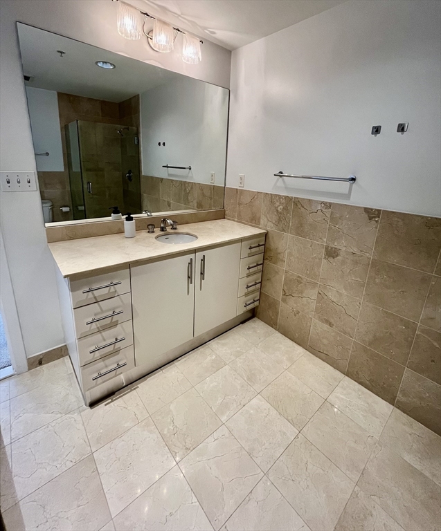 210 South Street, Unit 113 Boston, MA 02111 - Photo 16 of 17 a bathroom with a sink a vanity and a mirror