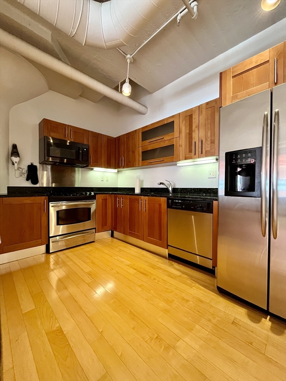 210 South Street, Unit 113 Boston, MA 02111 - Photo 8 of 17 a kitchen with stainless steel appliances granite countertop a sink and cabinets