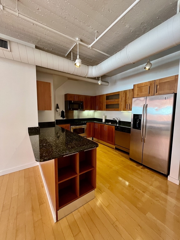 210 South Street, Unit 113 Boston, MA 02111 - Photo 10 of 17 a kitchen with stainless steel appliances granite countertop a stove a sink and a refrigerator