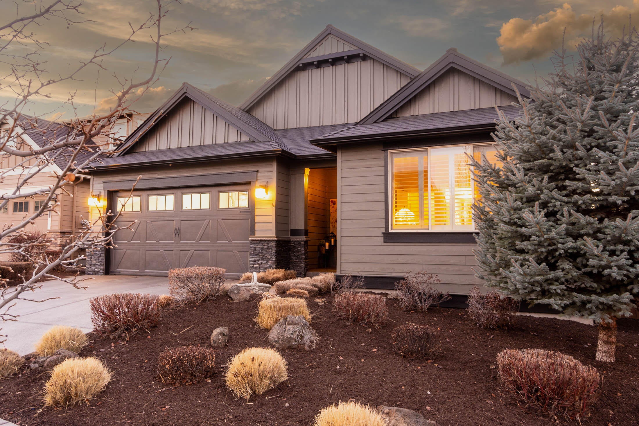 61129 Manhae Loop Bend, OR 97702 - Photo 1 of 44 Front exterior has stone masonry accents and exposed aggregate driveway and walk to covered front porch.