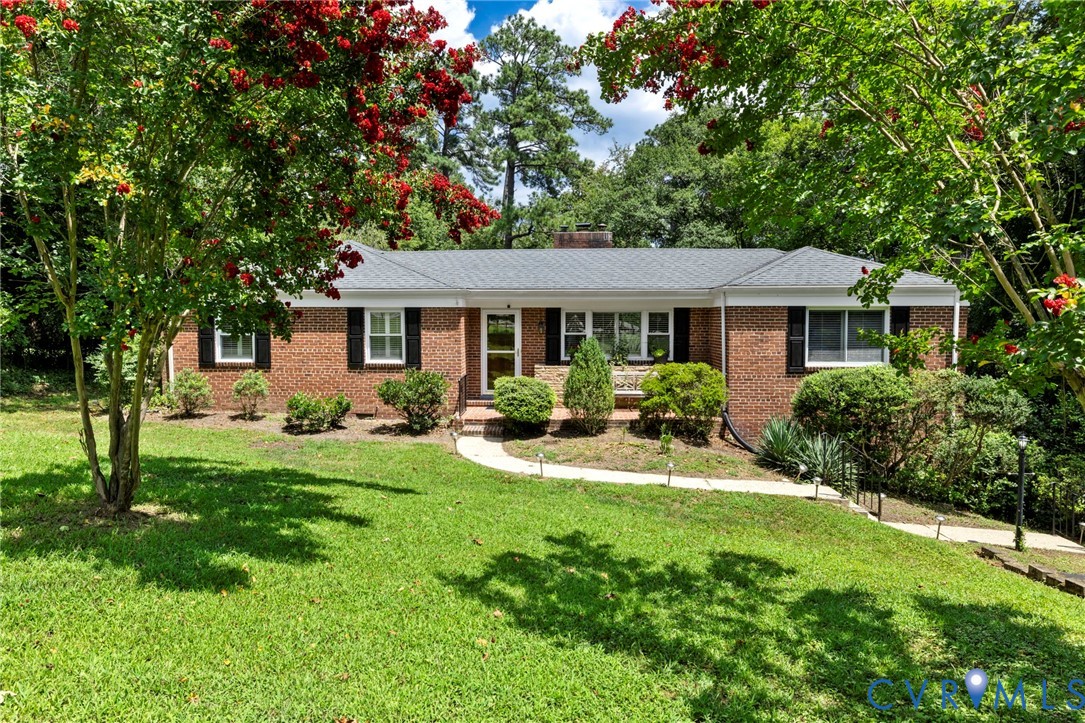 Ranch-style house with a front yard, brick siding,
