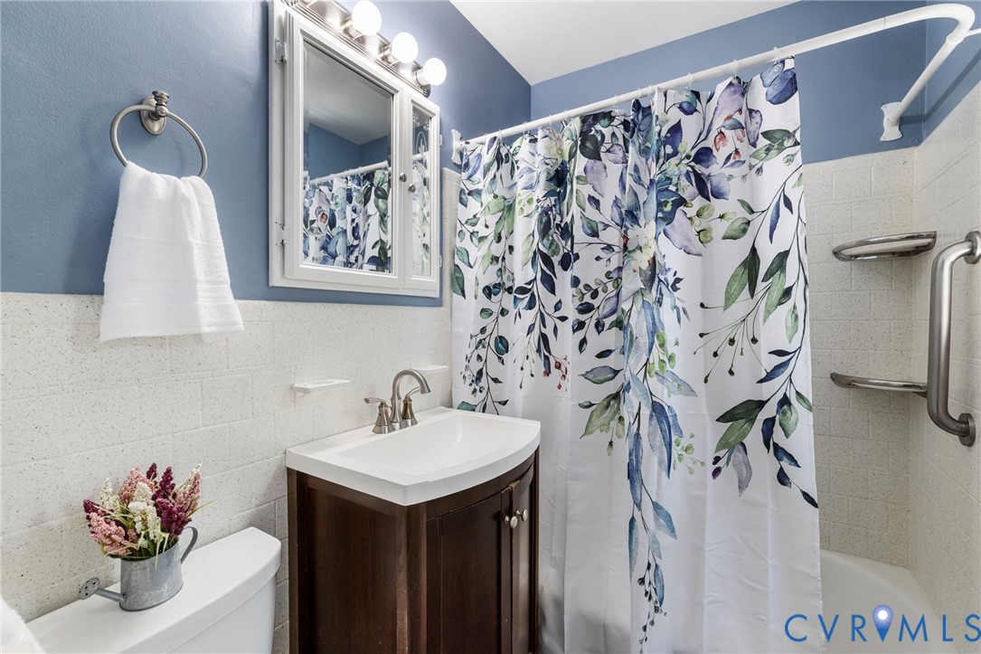 7644 Cherokee Road Richmond, VA 23225 - Photo 14 of 31 Bathroom featuring vanity, tile walls, shower / tu
