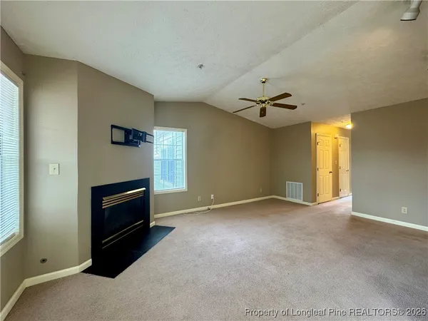 a view of an empty room with a fireplace and a window