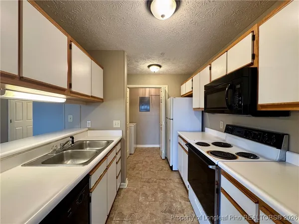 a kitchen with stainless steel appliances a sink a stove cabinets and a kitchen island