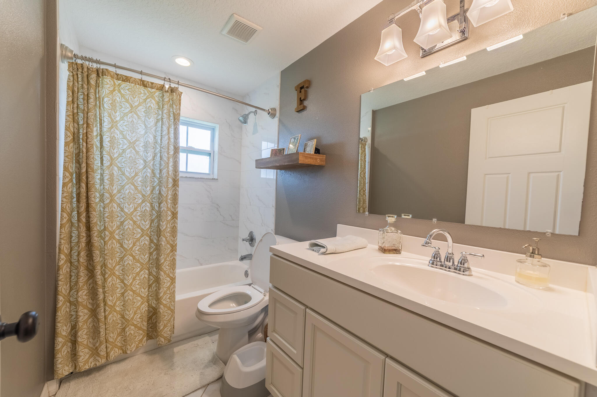 2675 Southwest 24th Avenue Okeechobee, FL 34974 - Photo 48 of 60 a bathroom with a granite countertop sink a toilet a mirror and shower