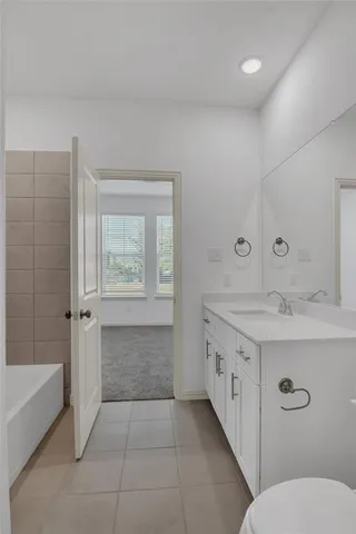 a bathroom with a granite countertop sink a toilet and bathtub