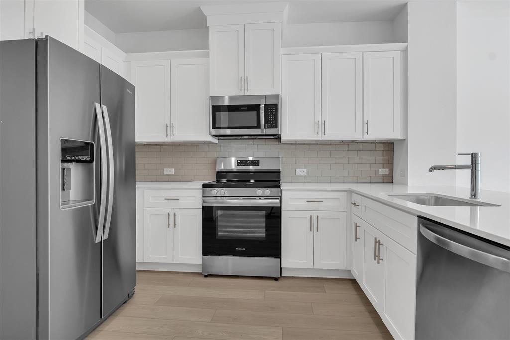5258 Springlake Parkway Haltom City, TX 76117 - Photo 18 of 24 a kitchen with white cabinets and stainless steel appliances