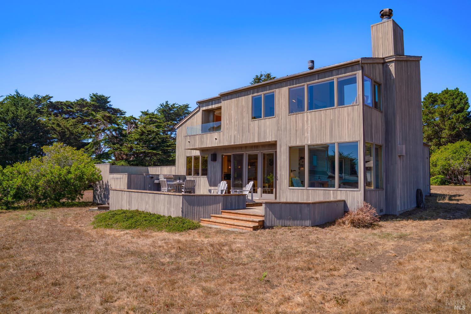 a front view of a house with sitting area and garden