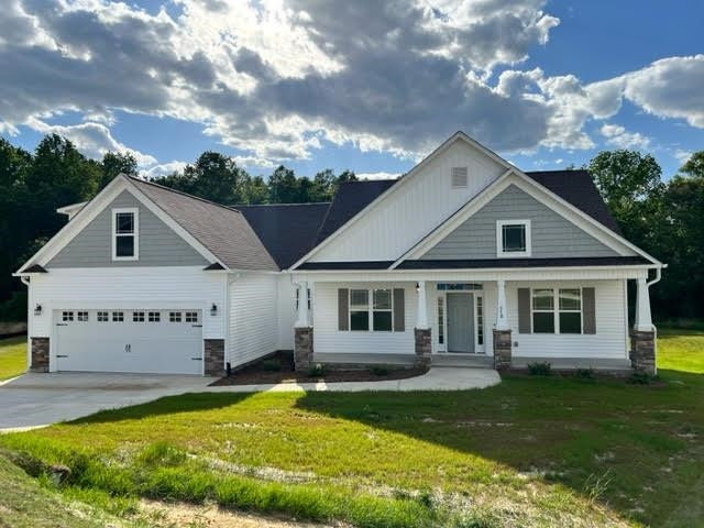 a front view of a house with a garden and trees