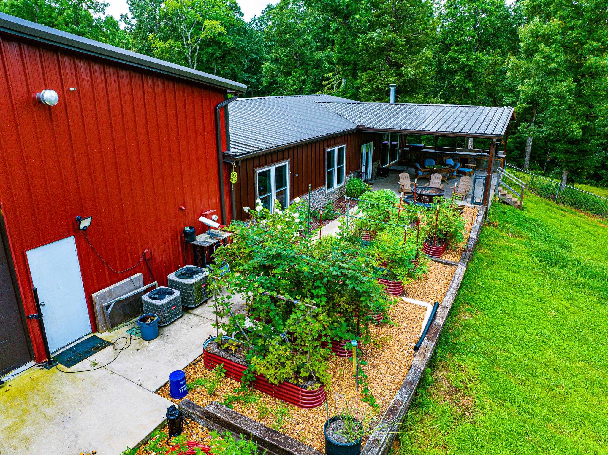 350 Hamilton Road Springville, TN 38256 - Photo 33 of 40 Exterior featuring a covered patio, terraced garden beds, concrete walkway, and a metal roof