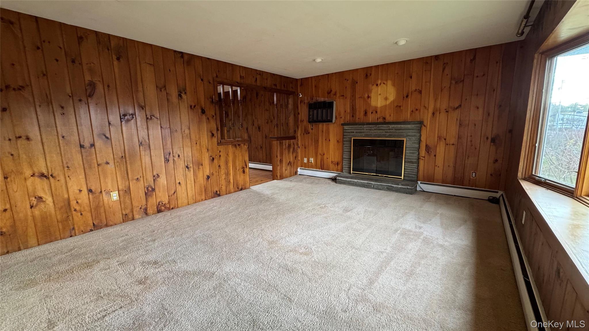 107 Noxon Road Poughkeepsie, NY 12603 - Photo 10 of 38 a view of an empty room with a fireplace and a window