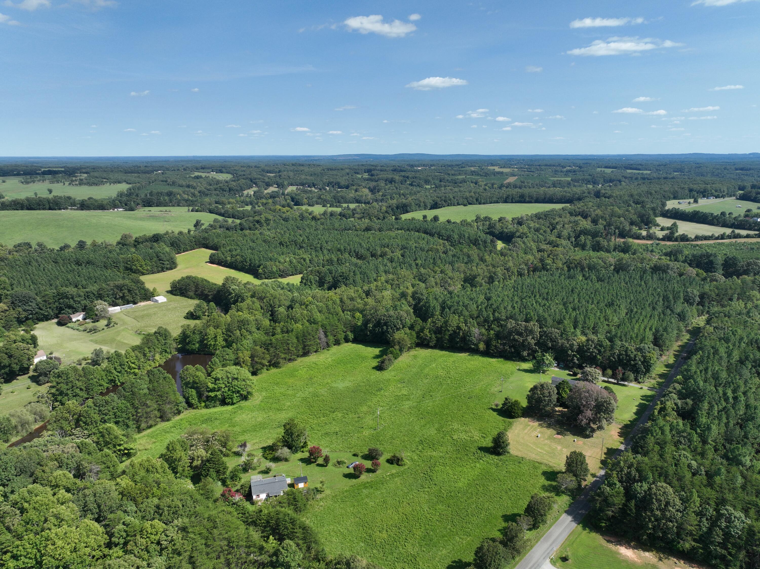1494 Green Bay Road Chatham, VA 24531 - Photo 33 of 54 an aerial view of green landscape with trees houses and mountain view