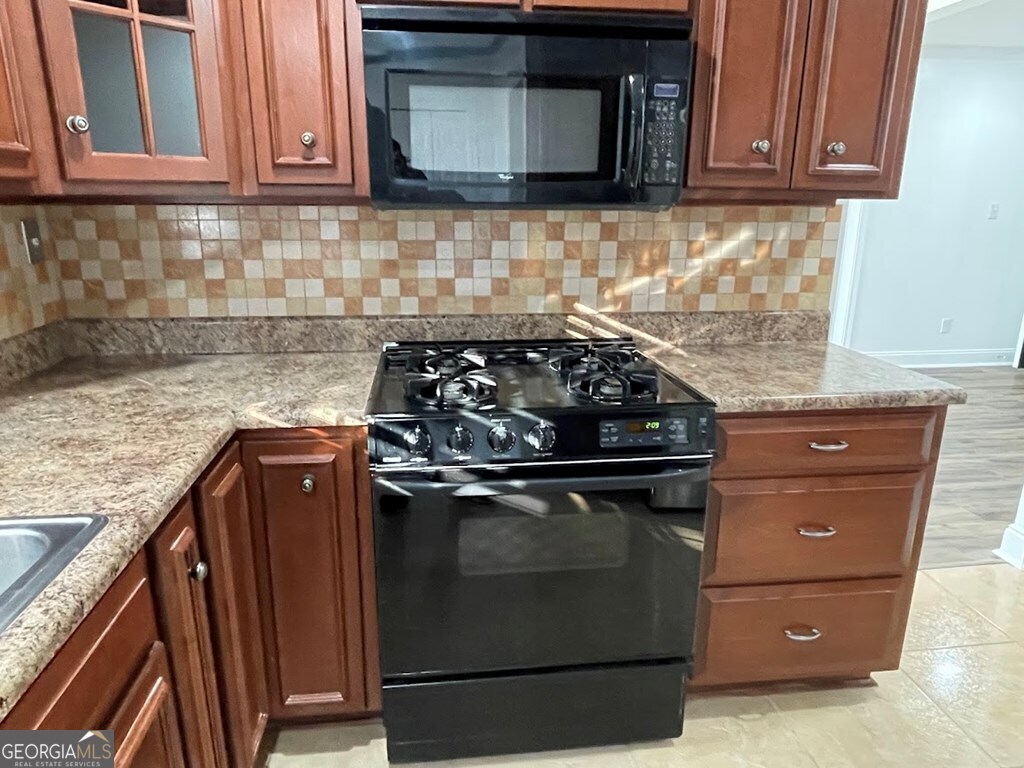 2311 St George Lane Albany, GA 31707 - Photo 13 of 39 a kitchen with granite countertop a stove top oven microwave and cabinets