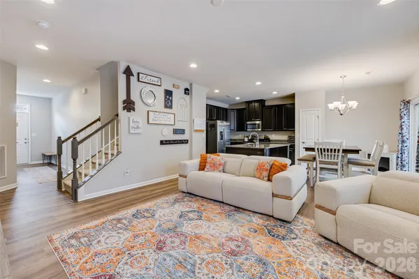 a living room with furniture and kitchen view with wooden floor