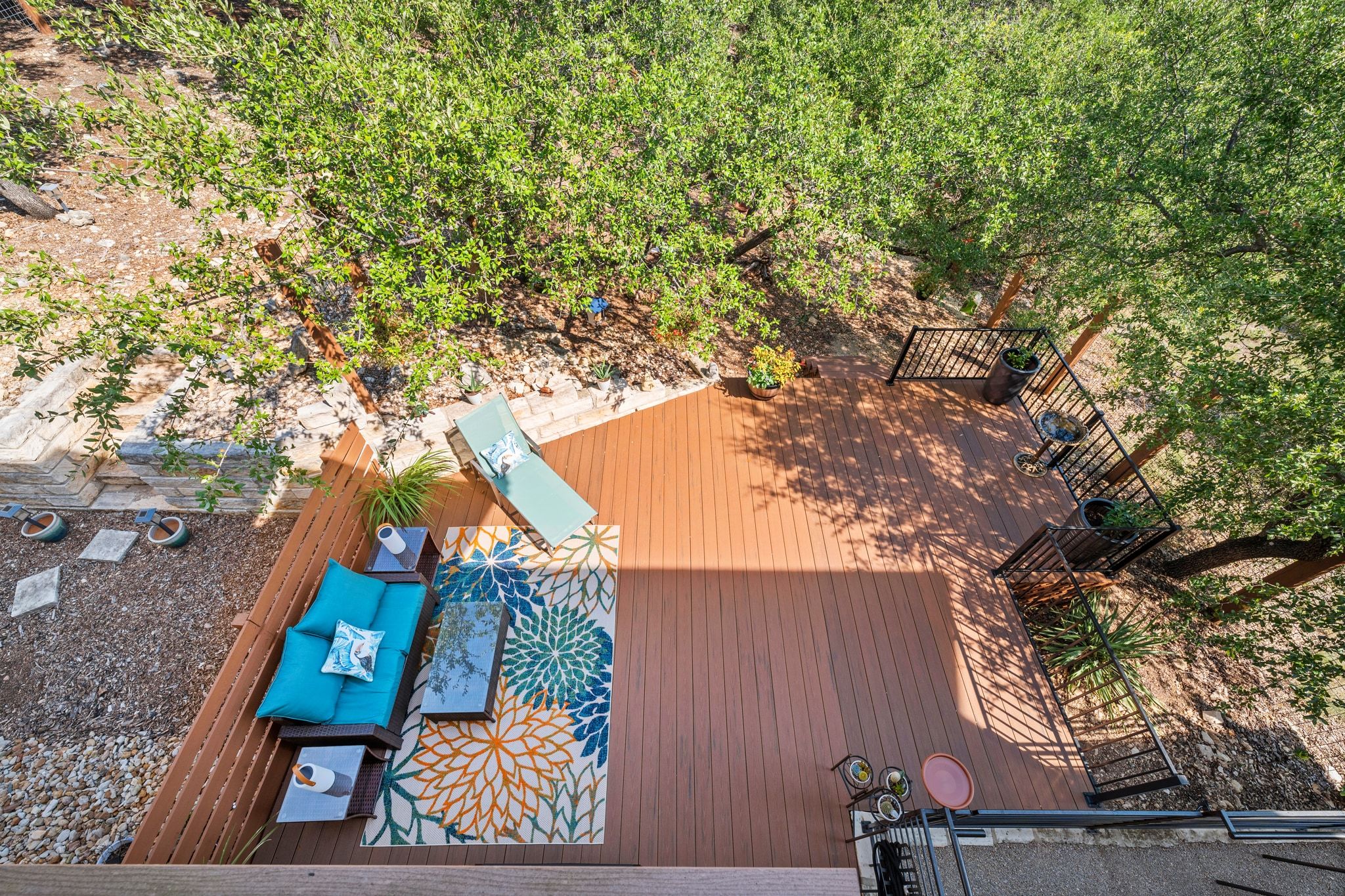 8110 Ranch Road 2222, Unit 92 Austin, TX 78730 - Photo 36 of 40 Expansive multi-level wood-finish deck with black metal railings, surrounded by mature trees