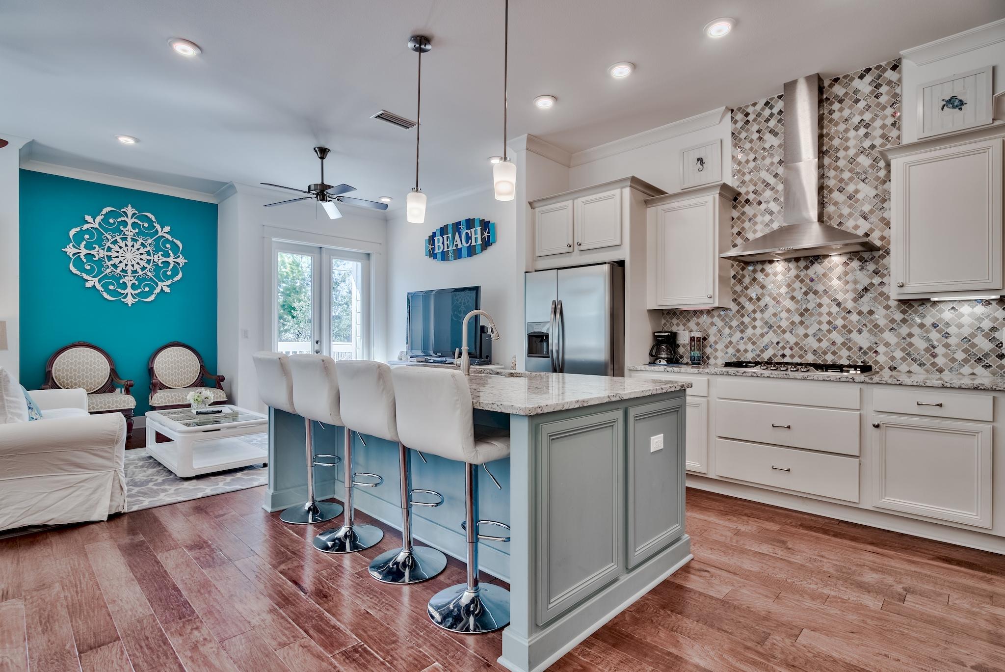 18 Milestone Drive Inlet Beach, Unit A Inlet Beach, FL 32461 - Photo 5 of 39 a large white kitchen with a large island oven a stove dining table and chairs