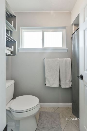 1267 North Erwin Street Ridgecrest, CA 93555 - Photo 22 of 35 a white toilet sitting next to a window in a bathroom