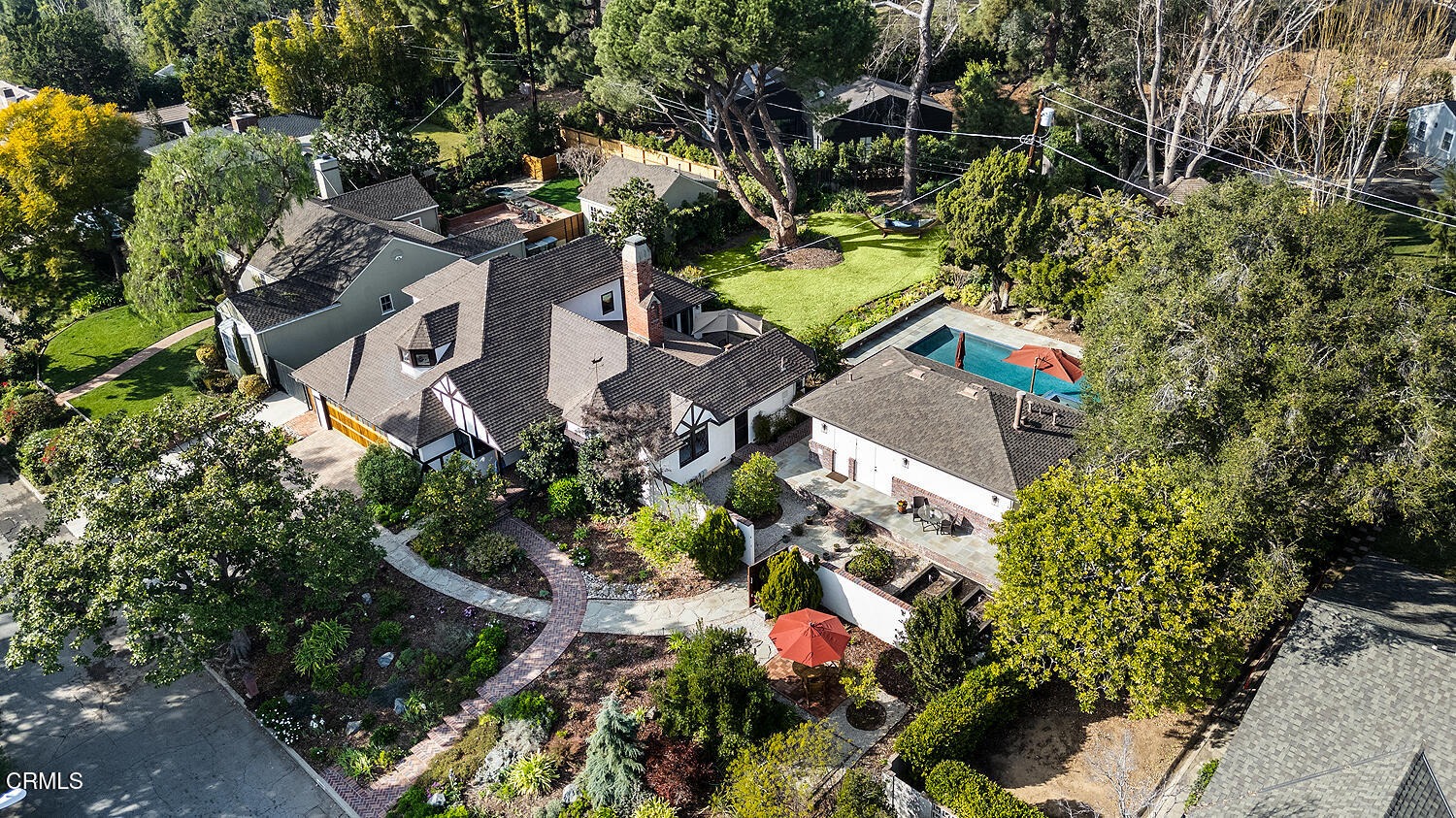 an aerial view of residential house with outdoor space and covered with trees