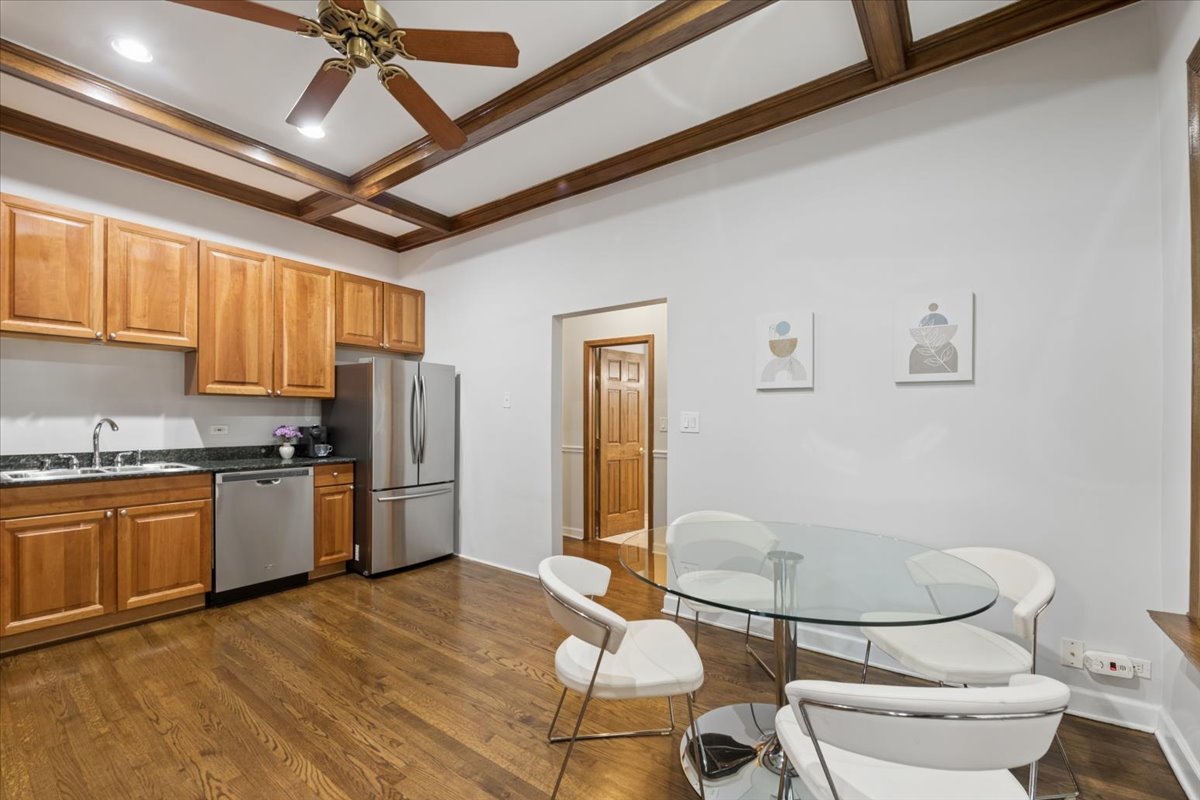 4028 North Sheridan Road, Unit 1R Chicago, IL 60613 - Photo 6 of 15 a kitchen with stainless steel appliances granite countertop a refrigerator a stove a sink dishwasher a dining table and chairs with wooden floor