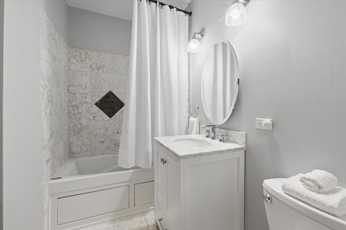 4028 North Sheridan Road, Unit 1R Chicago, IL 60613 - Photo 9 of 15 a bathroom with a sink a toilet and shower