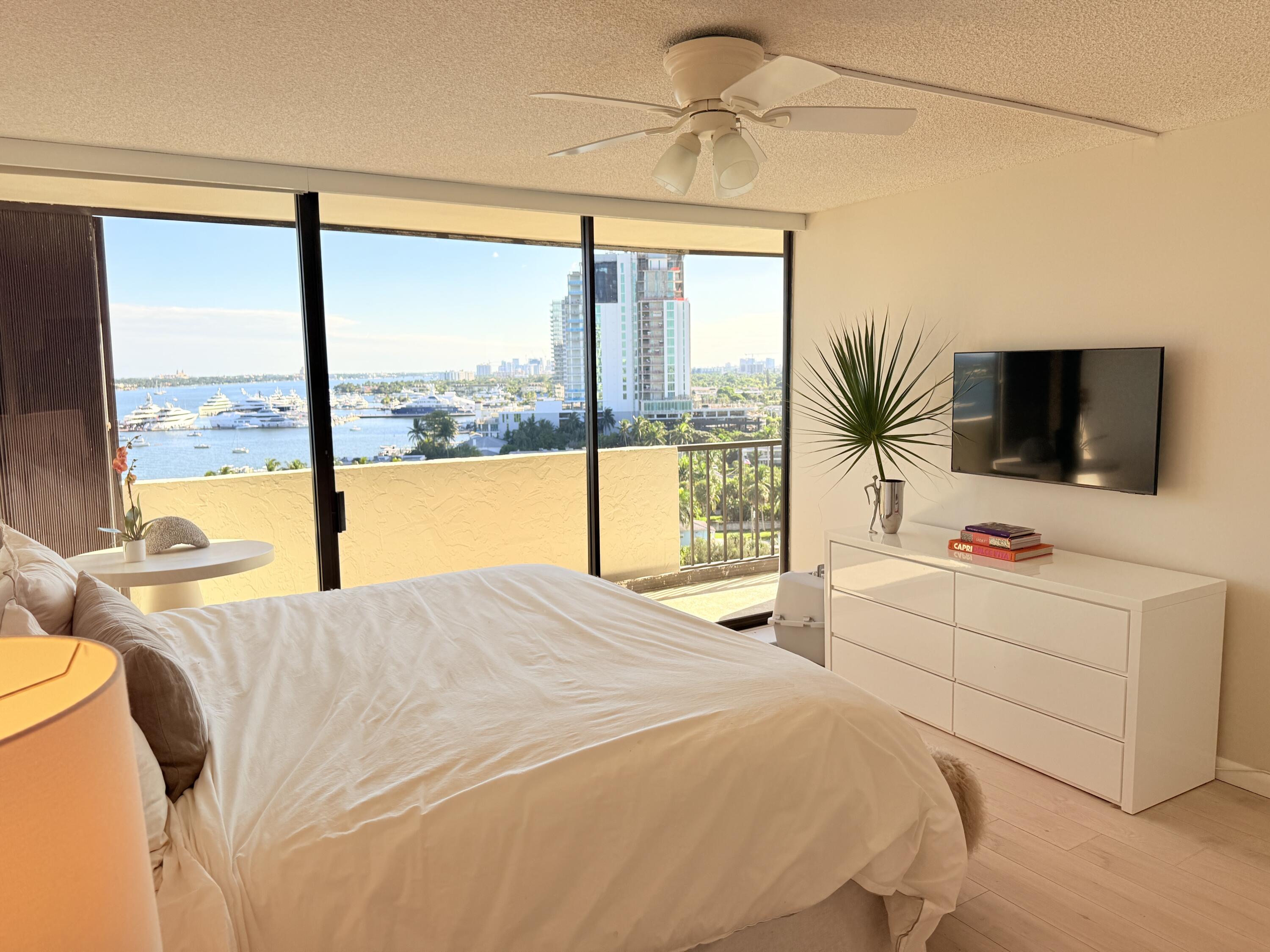 5200 North Flagler Drive, Unit 1406 West Palm Beach, FL 33407 - Photo 20 of 31 a bedroom with a bed and a flat tv screen next to a window