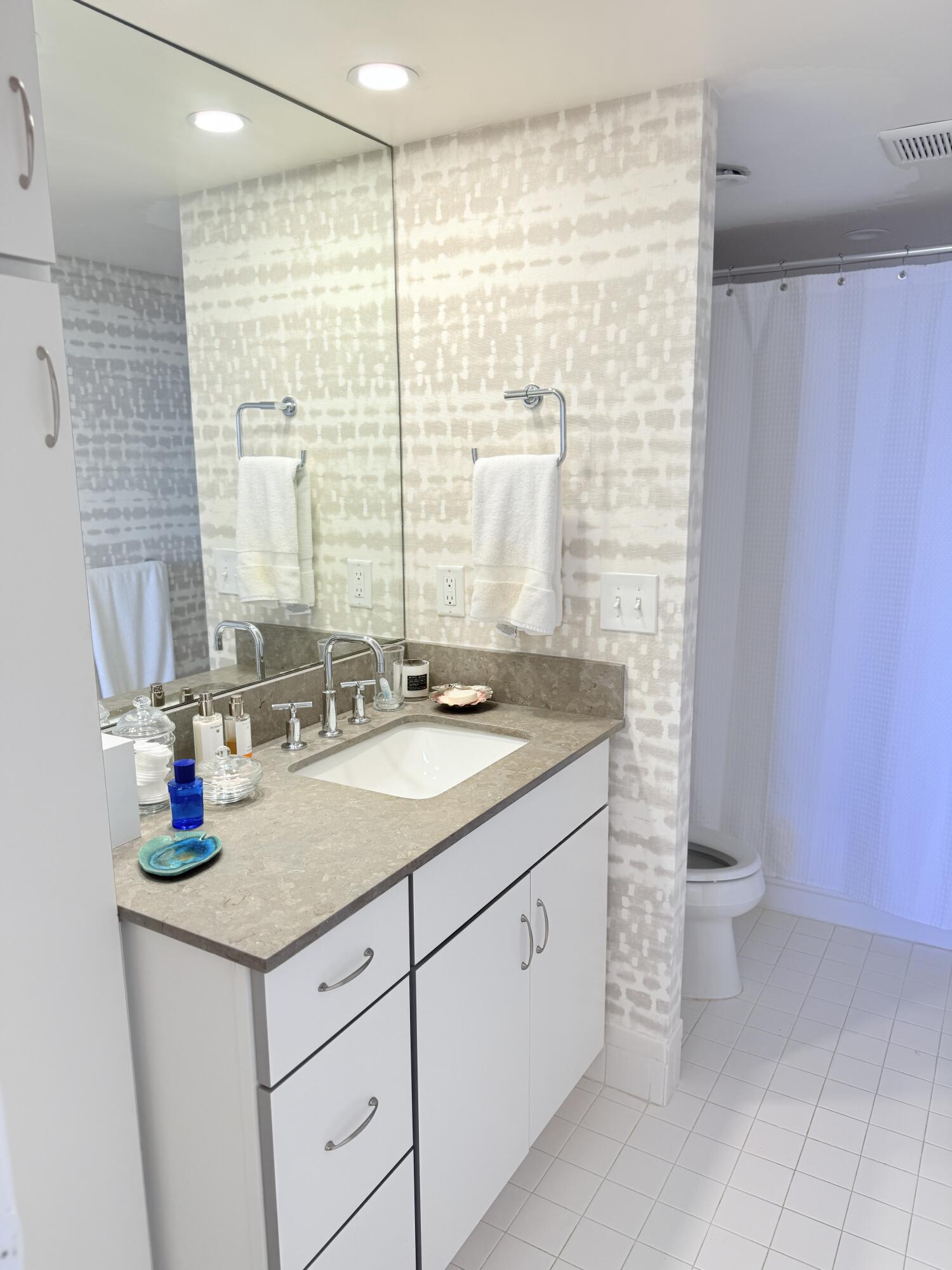 5200 North Flagler Drive, Unit 1406 West Palm Beach, FL 33407 - Photo 23 of 31 a bathroom with a granite countertop sink a toilet and a shower