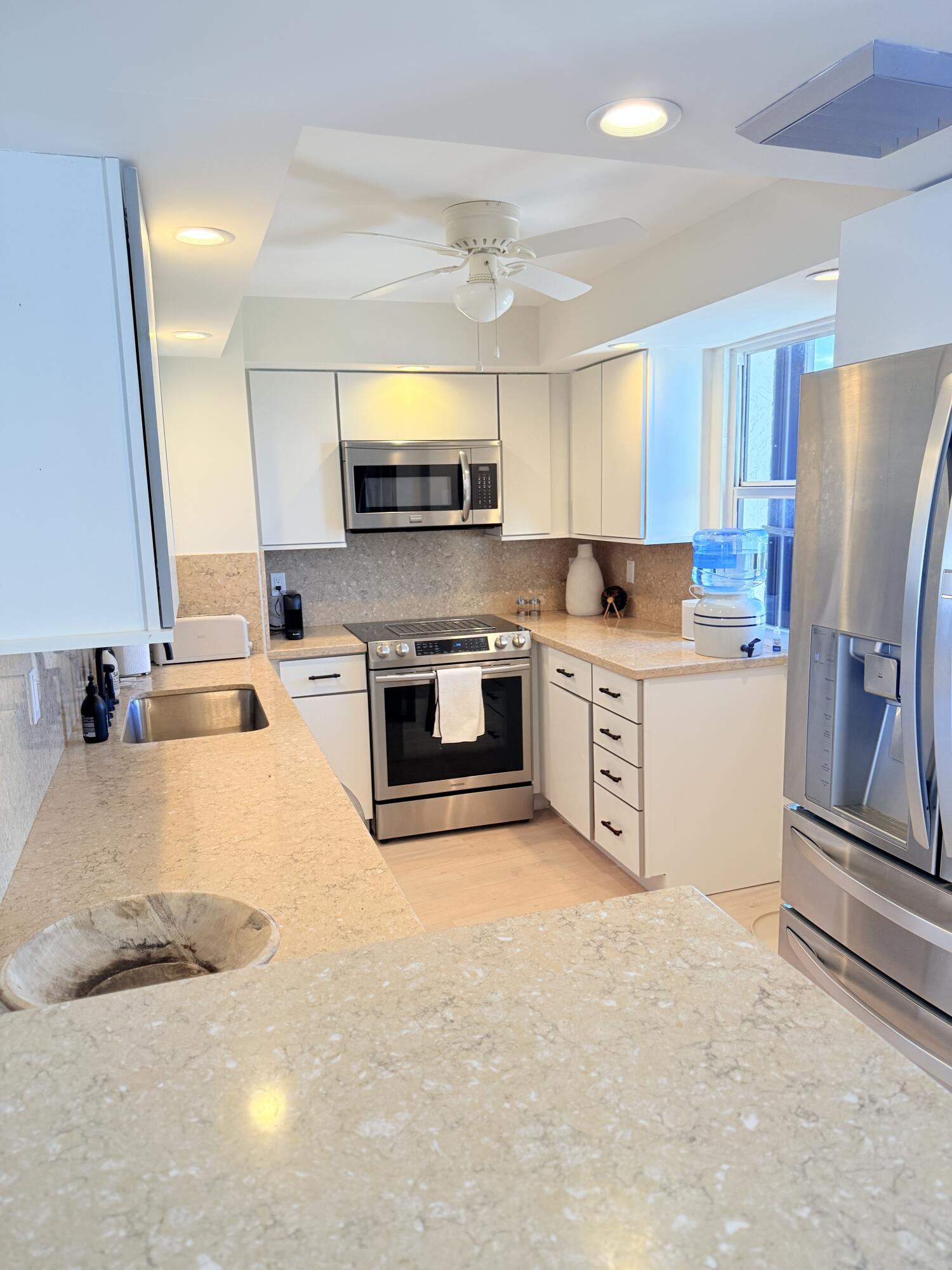 5200 North Flagler Drive, Unit 1406 West Palm Beach, FL 33407 - Photo 8 of 31 a kitchen with a stove a sink and a refrigerator