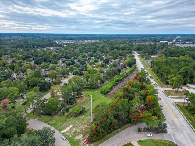 an aerial view of residential houses with outdoor space and trees
